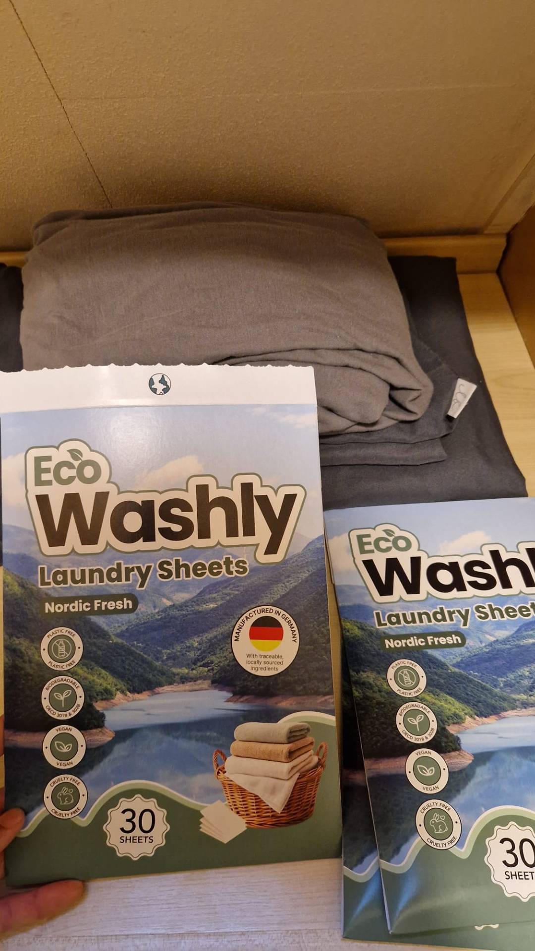 EcoWashly verpakking op stoffen achtergrond – biologisch afbreekbare wasstrips met FSC-gecertificeerde papieren verpakking.